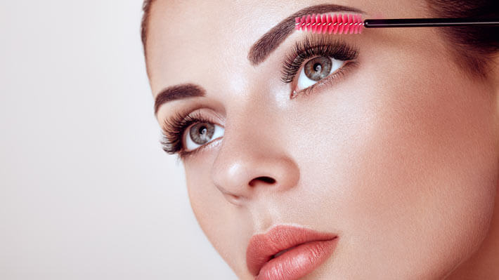 woman brushing her eyelash extensions